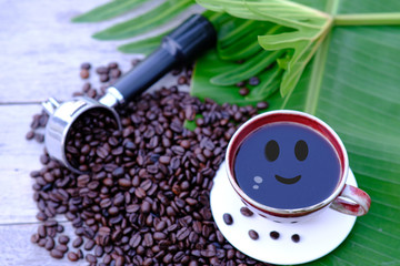 Canvas Print - Coffee cup and coffee beans on wooden table background