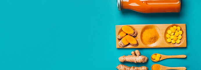 Wall Mural - Turmeric in different states: fresh in bottle, pills, powder and cut plant on wooden tray, dry root in wooden bowl.