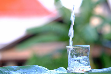 Poster - Close up pouring purified fresh drink water from the bottle on wood counter and space for text