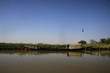 długie spiczaste czółno zacumowane przy trawiastym wybrzeżu spokojnej rzeki niger w afryce i czyste błękitne niebo