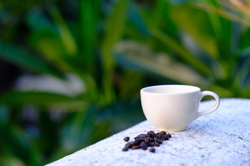 Canvas Print - Coffee cup and coffee beans on wooden table background