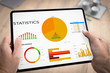 © Chlorophylle - Tablette numérique tenue en main par un homme au travail avec une présentation de graphiques d'évolution de chiffre d'affaires et de statistiques