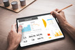 © Chlorophylle - Tablette numérique tenue en main par un homme au travail avec une présentation d'affaires avec des graphiques de données et des statistiques