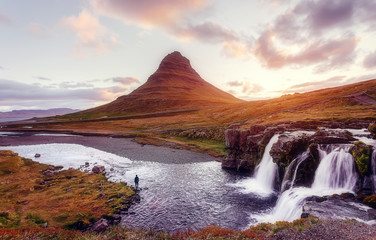  Scenic image of Iceland. Great view on famouse Mount Kirkjufell with Kirkjufell waterfall with colorful sky during sunset. Wonderful Nature landscape. Iconic location for landscape photographers
