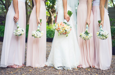 Bridesmaids standing holding bouquet  in hands