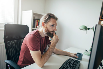 Wall Mural - Hipster man working on computer from his home