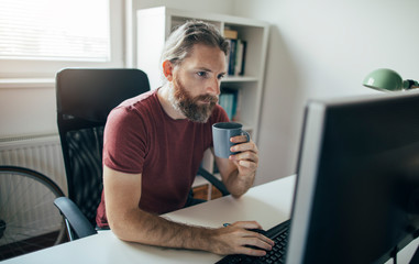 Ginger beard man working on computer. Working from home