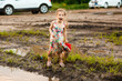© andrey - little girl goes in dirty dirt road after rain.