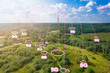 Telecommunication tower with radio antennas and satellite dishes is installed on the rural on the green field with grass, bushes and trees. Concept of harmless of electromagnetic and microwave