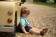 Little boy sulking by toy car