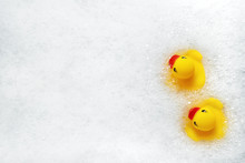 High Angle View Of Yellow Rubber Duck In Bath Swimming In Foam Water. Yellow Rubber Ducklings In Soapy Foam.