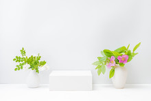 Empty White Box And Flowers In A Vase On A Light Background. Mockup Banner For Display Of Advertise Product