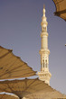 Medina mosque minaret and sun umbrellas