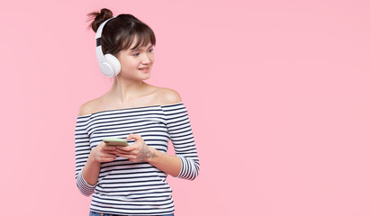 5G Unlimited Internet Advertising. Portrait of young cheerful asian woman using mobile phone and listening to music on wireless headphones.
