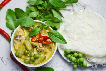 Thai food green curry chicken on soup bowl and thai rice noodles vermicelli with ingredient herb vegetable - asian food on the table