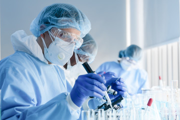 Wall Mural - biochemical research scientist team working with microscope for coronavirus vaccine development in p