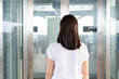 © DG PhotoStock - Young Asian woman waiting for the elevator by standing in front of the elevator gate.
