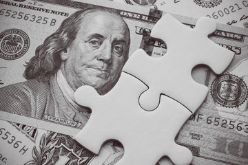 Wall Mural - Benjamin Franklin president on US dollar banknote under unfinished white jigsaw puzzle. USA or world economy crisis situation due to US - China trade war and currency war, business strategy, problem