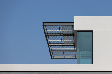 Poster - steel awning of modern house. exterior metal louver shading against blue sky.