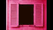 Vivid pink colored wooden window with opening shutters on brick wall	