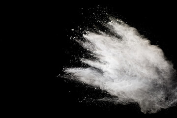 White powder explosion isolated on black background.White dust particles splash.