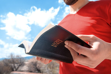 Wall Mural - man hand Holy Bible in nature