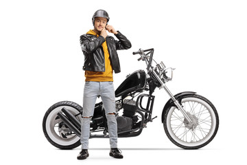 Poster - Young biker taking off helmet and standing next to chopper motorbike