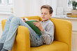 © contrastwerkstatt - Young boy relaxing at home reading a book