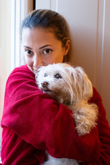  ritratto di una ragazza chiara con gli occhi grandi e scuri vestita di rosso vicina al suo cane di razza maltese