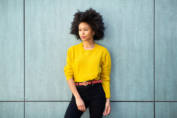 Wall Mural - african american female fashion model with afro hair posing by green wall