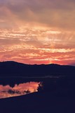 Fototapeta Na drzwi - Lake reflecting colorfully clouds at sunset
