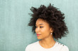 © mimagephotos - Close up beautiful young african american woman with afro hair by green background