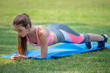 © iammotos - Beautiful  fitness young woman in sportswear doing plank on mat in park . sport Fit girl push up exercise in morning . healthy lifestyle concept.  workout . training. endurance . smile