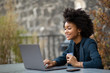 © mimagephotos - african american businesswoman sitting outside with laptop computer