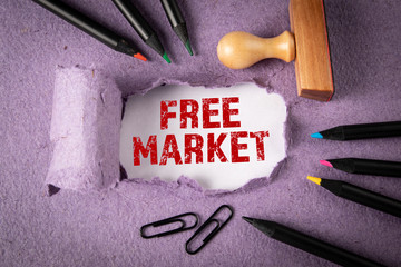 Canvas Print - FREE MARKET concept. Text under torn paper. Colored pencils and office supplies