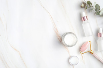 flat lay spa natural organic cosmetic on marble background. top view moisturizer cream, serum bottle