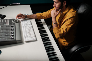 Wall Mural - Man working on music controllers at home studio