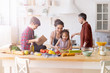 Children and parents cook together at home in the kitchen