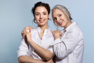 loving senior mother hugging adorable adult daughter portrait.
