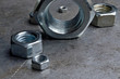 © Oleg - Hex nuts of various sizes spread on a metal surface. assorted closeups.