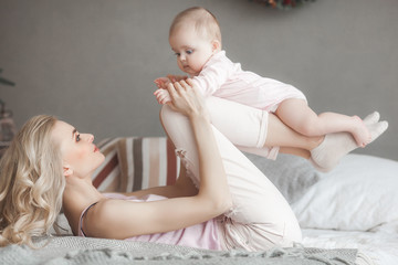 Wall Mural - Young mother with little baby. Mommy holding her cute child. Maternity concept.