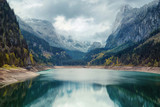 Fototapeta Góry - Alpine lake with dramatic sky and mountains
