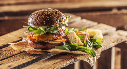 Canvas Print - Home made tasty burger with bacon onion cheese ane lettuce on wooden box