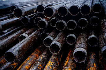 Wall Mural - Oil Drill pipe. Rusty drill pipes were drilled in the well section. Downhole drilling rig. Laying the pipe on the deck. View of the shell of drill pipes laid in courtyard of the oil and gas warehouse