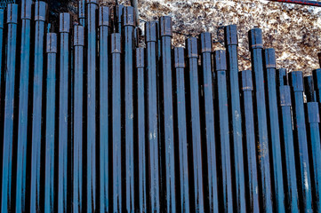 Wall Mural - Oil Drill pipe. Rusty drill pipes were drilled in the well section. Downhole drilling rig. Laying the pipe on the deck. View of the shell of drill pipes laid in courtyard of the oil and gas warehouse