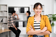 © Monster Ztudio - Confidence team leader. Young women asian owner startup business looking camera with smile while his colleagues working in the background