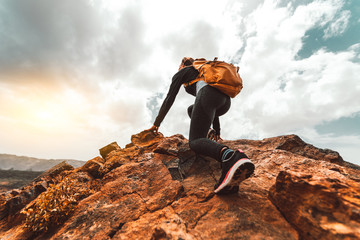 Wall Mural - success woman hiker hiking on sunrise mountain peak - young woman with backpack rise to the mountain