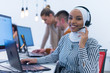 African muslim female with hijab scarf customer representative business woman with phone headset helping and supporting online with customer in modern bright call centre.