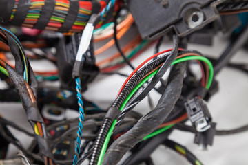 Canvas Print - Close-up of a power channel in a black insulating tape on a blurry background among multi-colored wires. Digital Internet network at the remote work of a developer programmer.