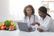 © Prostock-studio - African women dietician and patient looking at laptop screen
